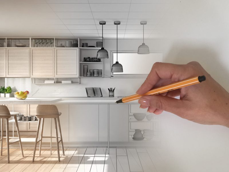 Architect interior designer concept: hand drawing a design interior project while the space becomes real, modern white and wooden kitchen with island and stools