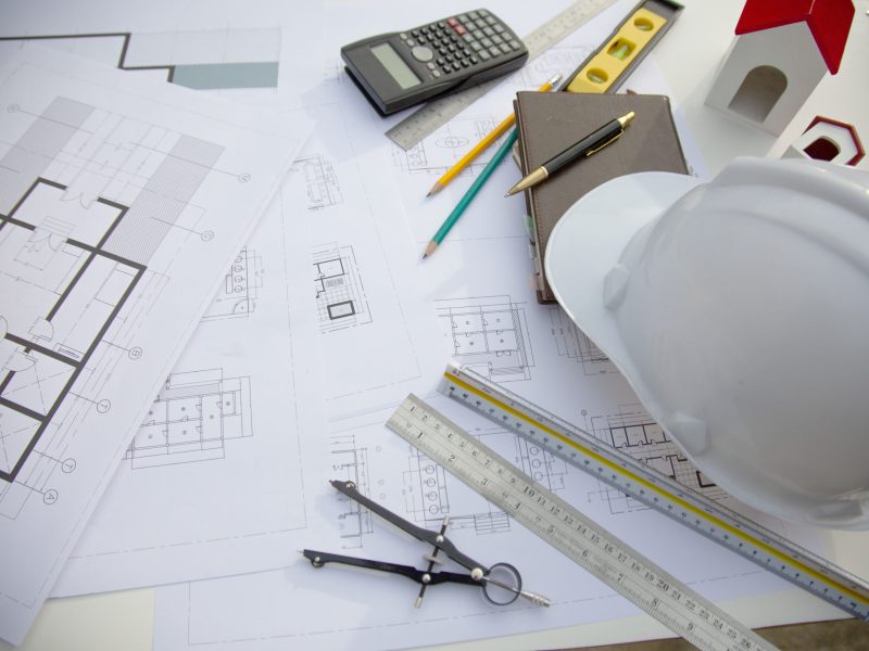 Desk of Architectural working project in construction site,With drawing equipment concept.