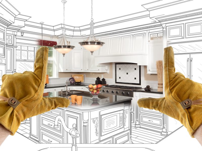 Male Contractor Hands Framing Completed Section of Custom Kitchen Design Drawing.