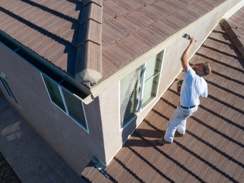 Professional Painter Using A Brush to Paint House Fascia.